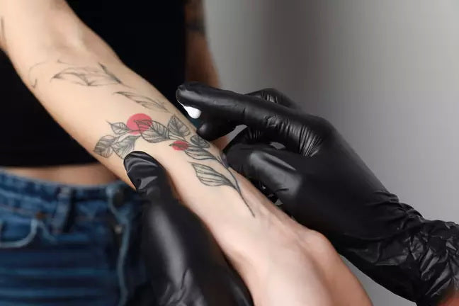 Professional tattoo artist doing tattoo. Portrait of a woman tattoo master  showing a process of creation tattoo on a legs. Tattooist machine,gun. Free  space to fill,text. Stock Photo | Adobe Stock